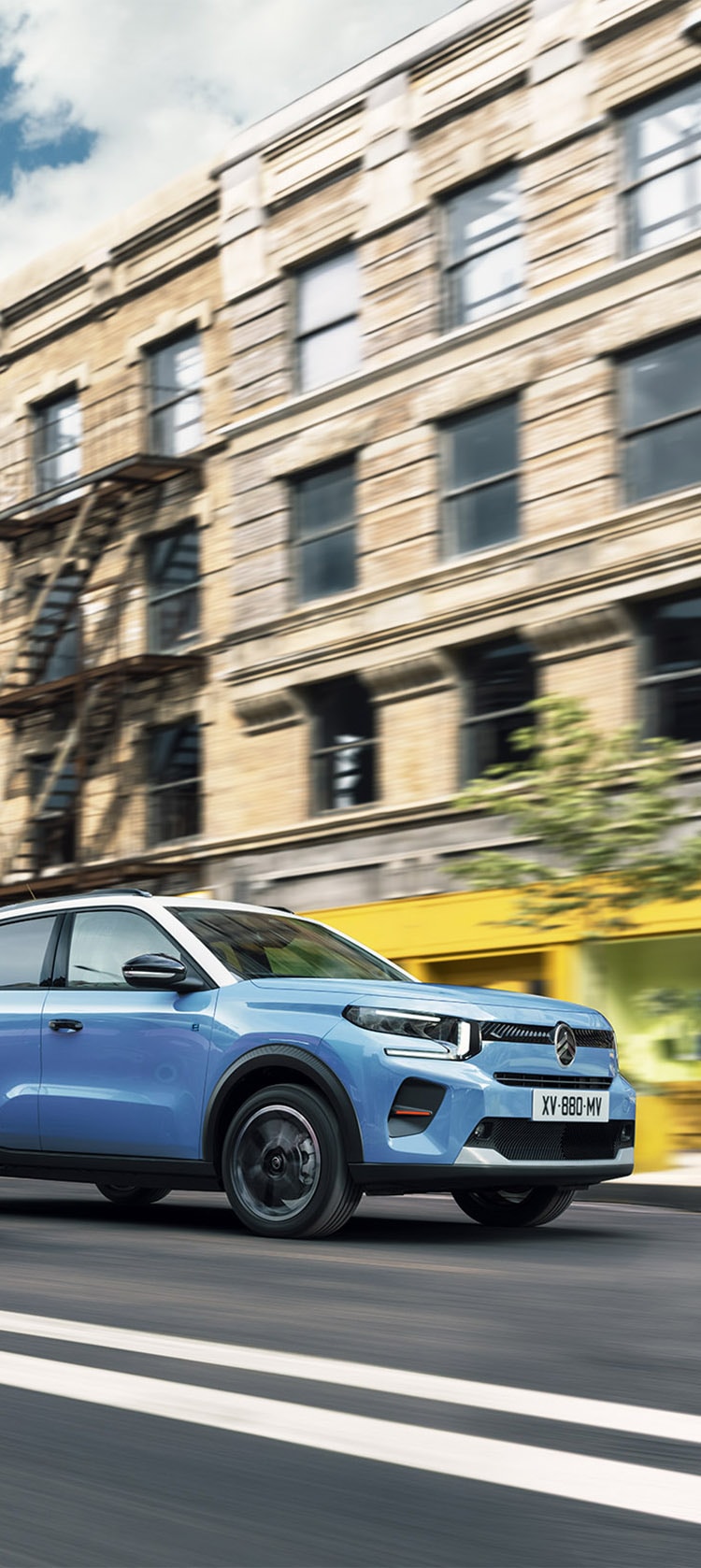 Citroën C3 Rouge avec coucher de soleil et ville en fond